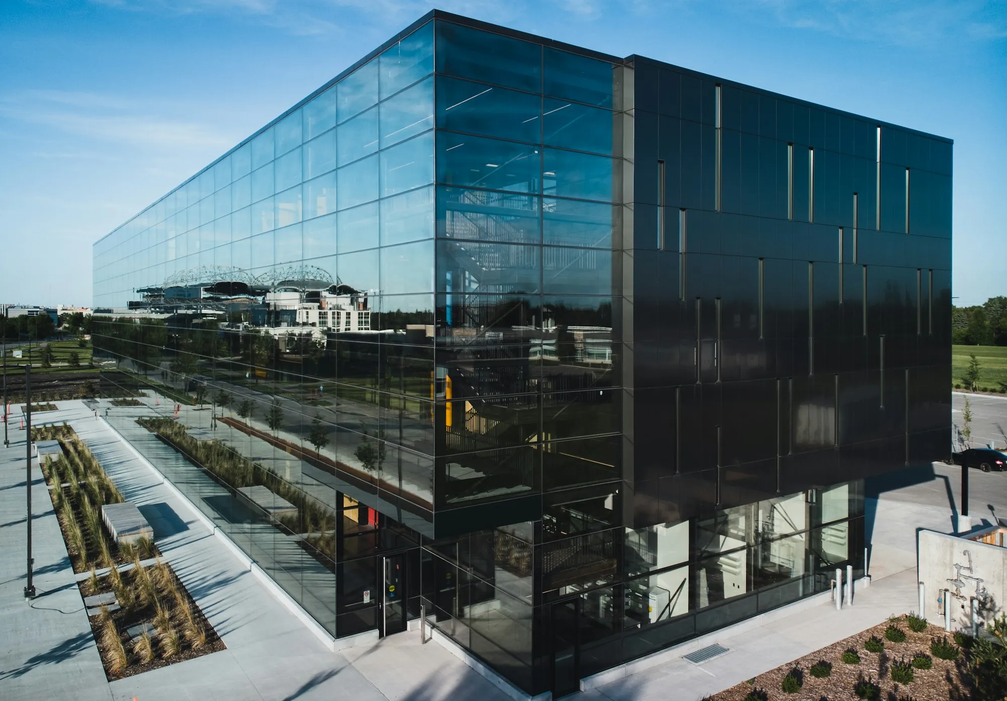 Glass-walled commercial building with a landscaped plaza